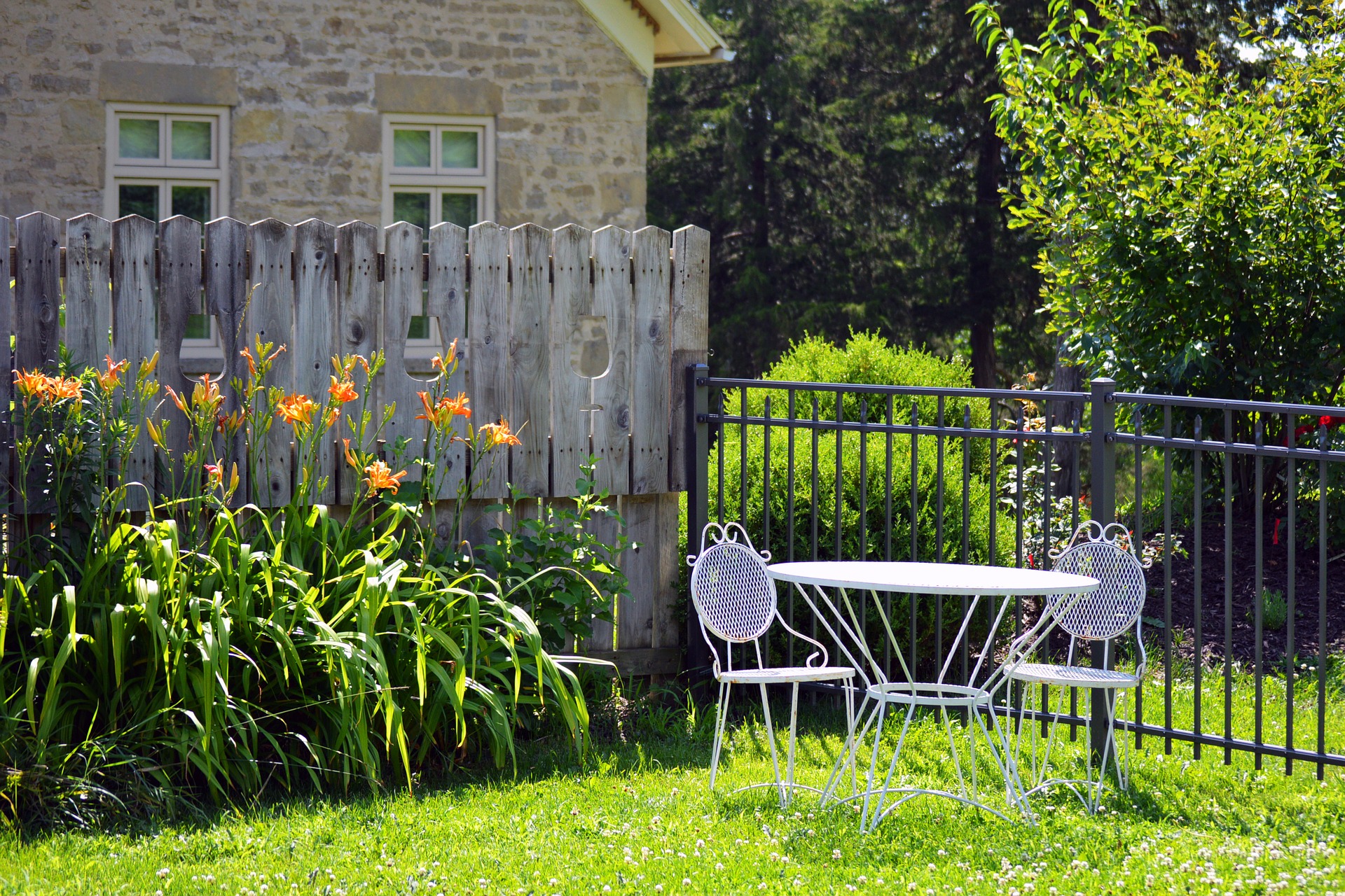 Jardin avec table et chaises et clôtures en métal et bois