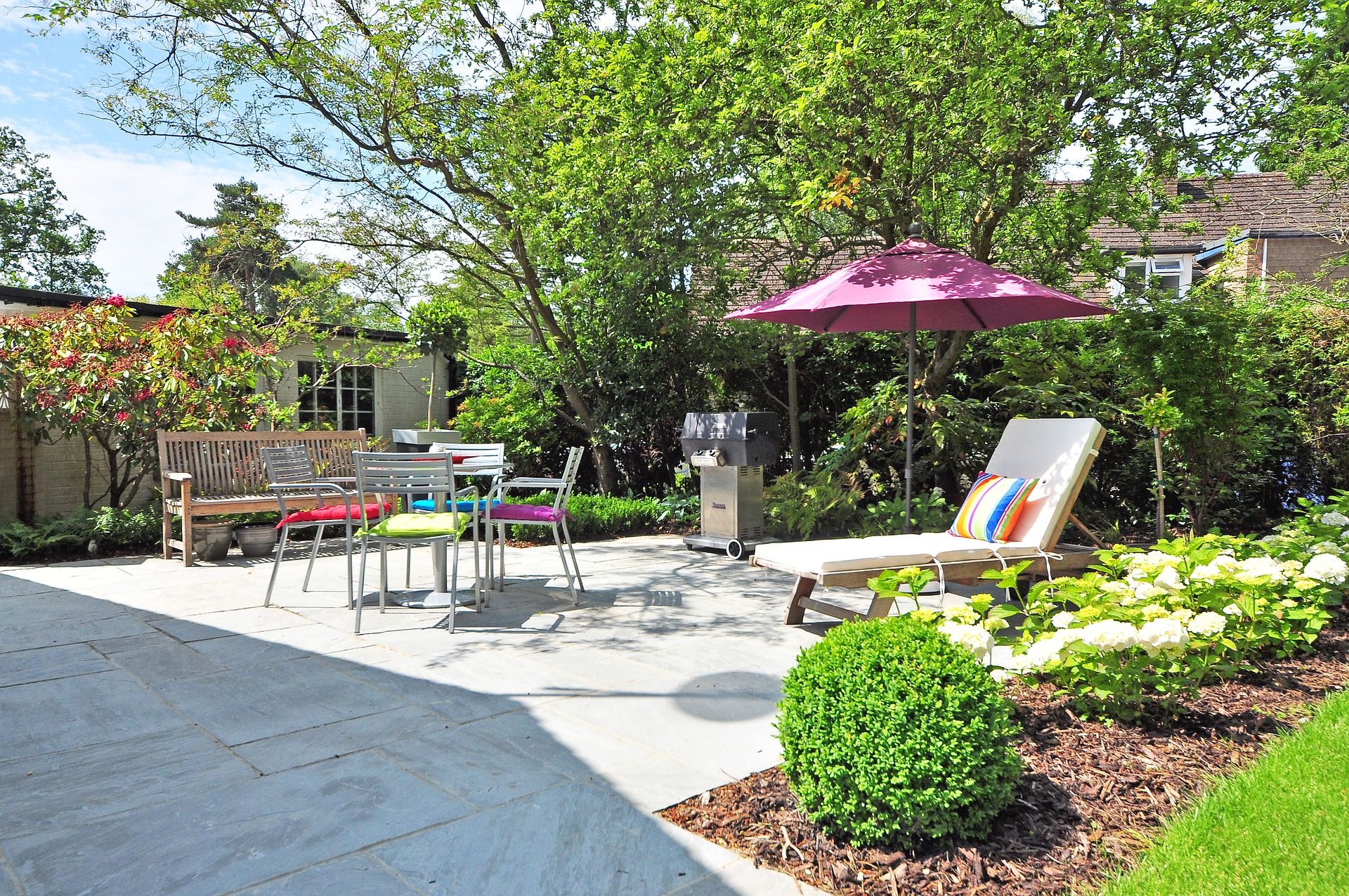 Jardin d'une maison avec une terrasse et un salon de jardin